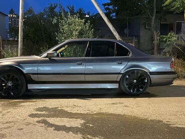 BMW: Tünd boz rəngdə olan BMW 7 Seriyası sedanı. Avtomobil qara rəngli