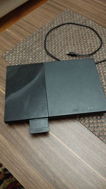 PS2 & PS1 (Sony PlayStation 2 & 1): Qara rəngdə olan Sony PlayStation 2 oyun konsolu. Daxilində yaddaş