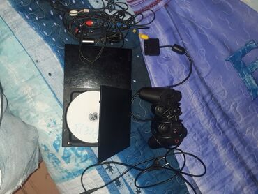 PlayStation 2 konsolu, qara rəngdədir. Konsolun içində disk yeri