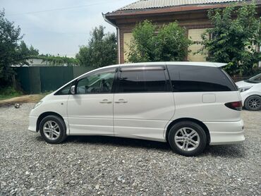 Белый минивэн Toyota Estima с плавными линиями кузова и темными