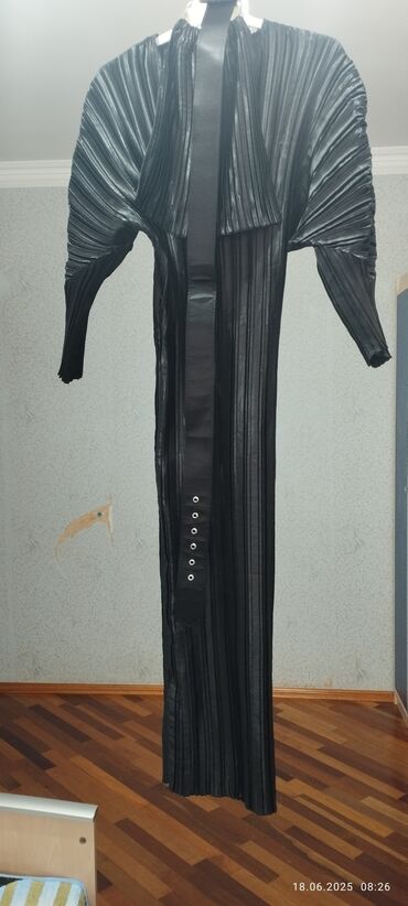 Paltolar: Qara rəngdə, uzun, plise detallı zərif abaya/palto-stil üst geyimi. -