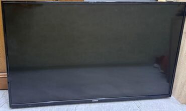 ucuz telvizorlar: Ekranı böyük olan qara rəngli televizor. Divara bərkidilməsi üçün
