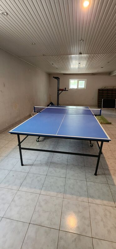 teze oyunlar: Mavi rəngdə, qatlanabilən stolüstü tennis masası. Oyun zamanı rahatlıq
