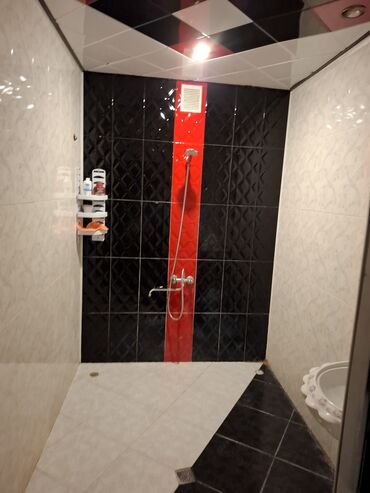 Unitazlar: Ağ və qara rənglərdə keramik plitələrlə döşənmiş müasir hamam. Hamam — 2