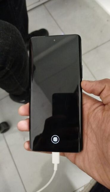 Digər mobil telefonlar: Bu qara rəngli smartfon, hamar dizaynı və minimalist görünüşü ilə