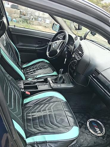 BMW: BMW E36 sedan kuzalı avtomobil. Tünd göy rəngdədir və klassik BMW — 5