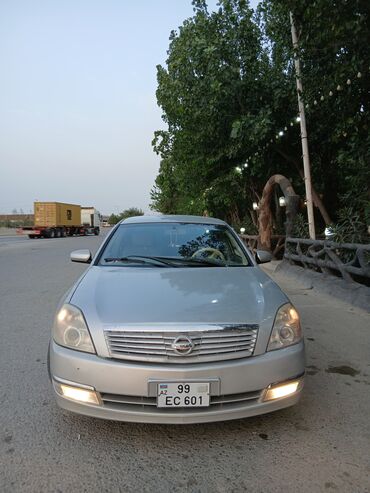 Gümüşü rəngli Nissan Teana avtomobili. Avtomobilin qabaq hissəsindəki