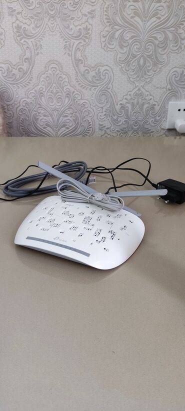 Modemlər və şəbəkə avadanlıqları: Ağ rəngdə, TP-Link markasına məxsus simsiz router. Evdə və ya ofisdə