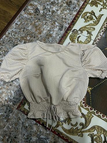 qadin koynek modelleri: Bej rəngli, xırda dama naxışlı qadın bluzu. Model qısa kəsimlidir və — 1