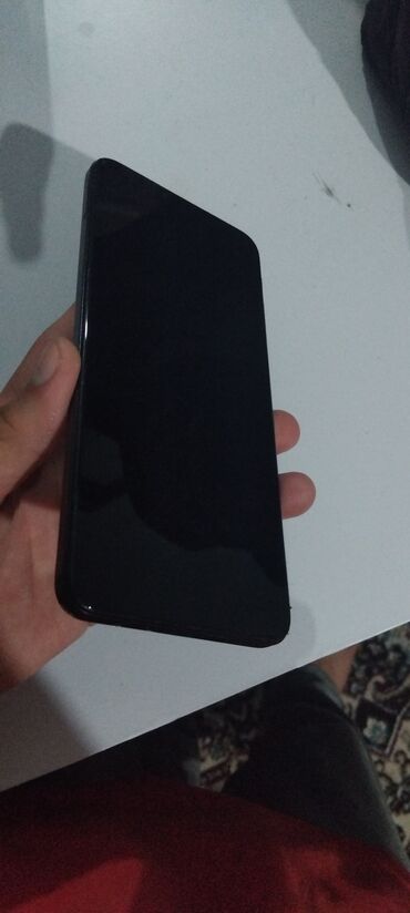 qulaqcıq qabı: Qara rəngdə, incə dizaynlı smartfon. Cihazın alt hissəsində USB Type-C