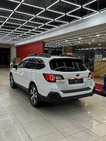 самая деловая машина: Автомобиль Subaru Outback белого цвета с черными рейлингами на крыше