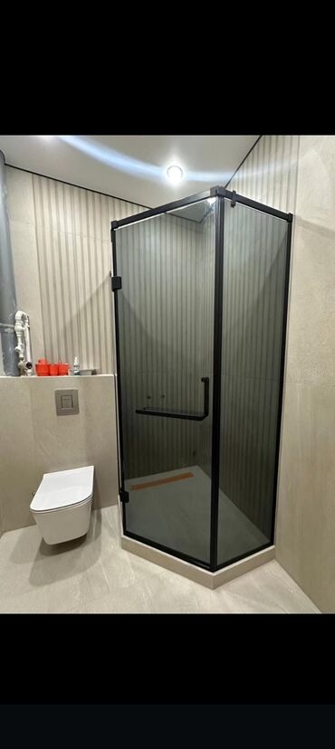 Hamam üçün kranlar: Şüşə duş kabinası qara çərçivə ilə. Bu kabina müasir hamam otaqları