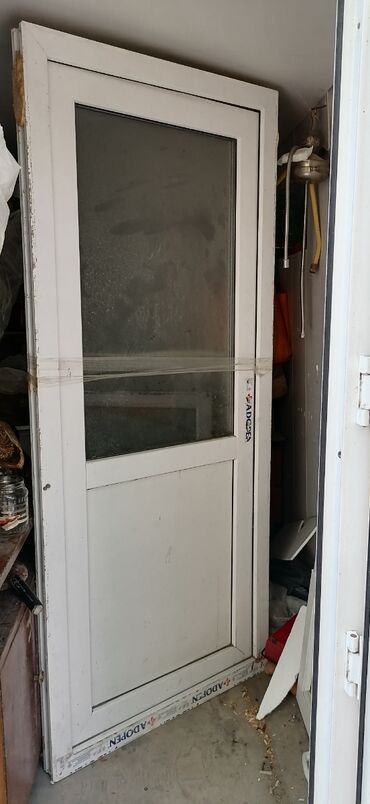 plasik qapi: ADOPEN markalı ağ rəngli PVC qapı. Bu qapı iki hissədən ibarət şüşə
