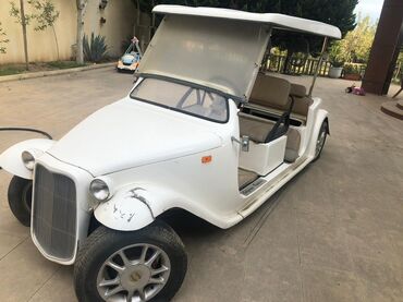 Digər Avtomobillər: Ağ rəngdə, açıq golf arabası. Üzərində qoruyucu örtüyü var