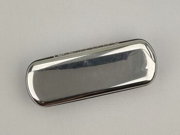 Owalne etui na okulary w kolorze srebrnym, wykonane z metalu. Wewnątrz