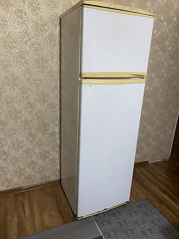 Двухкамерный холодильник белого цвета с верхней морозильной камерой