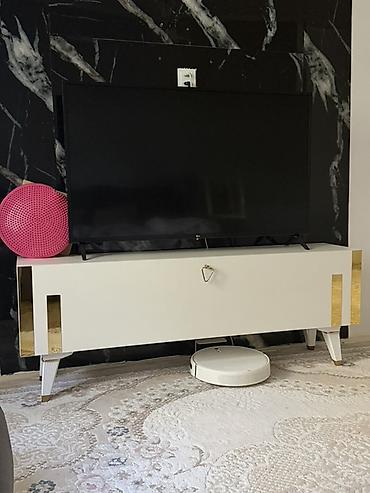 tv 43: Ağ rəngli, qızılı dekor detallarına malik TV tumbası

- — 1