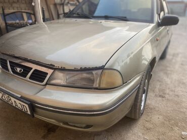 Автомобиль Daewoo Nexia золотистого цвета. Это практичный седан