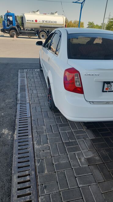 авто из кореи в бишкек: Белый седан Chevrolet Lacetti с эмблемой "LACTETTI" на задней части