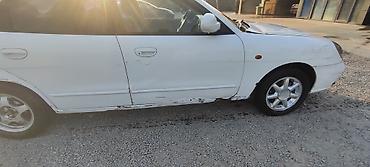 Другие автомобили: Белый седан компакт‑класса с передним приводом. Кузов 4‑дверный, на — 3