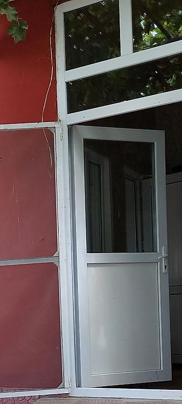 qapi alemi: Ağ rəngli PVC giriş qapısı və üst hissədə şüşəli transom paneli — 1