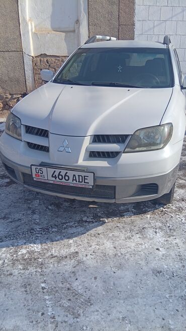 шумо и вибро изоляция: Внедорожник Mitsubishi Outlander белого цвета с рейлингами на крыше