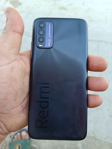 купить редми 9т бу: Redmi markalı tünd rəngli smartfon, arxa hissəsində üç kamera və bir