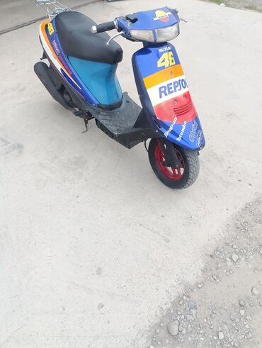 бус сапог мост: Скутер Suzuki в сине-желтой расцветке с наклейками Repsol и номером
