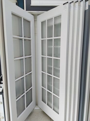 qoşa qapi: Ağ rəngli taxta çərçivəli qapı, hər biri 15 şüşə panellə bəzədilmiş