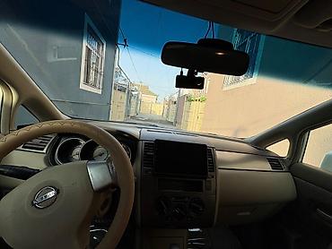 nisan note: Ağ rəngli Nissan Tiida sedan. Avtomobilin salonu açıq bej tonlarda — 8