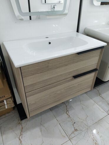 hamam ucun moydadır: Ağ rəngli keramika lavabo və taxta fakturalı dolabdan ibarət hamam