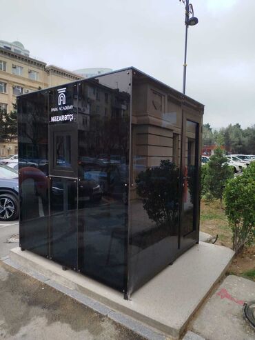 киоск: Qara rəngdə, müasir dizaynlı mühafizə kabinəsi. "Park Academy" loqosu