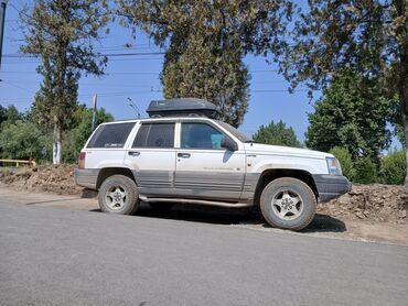 авто домкраты: Полноприводный внедорожник Jeep Grand Cherokee белого цвета