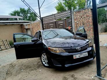 тико машына: Черный седан Toyota Camry с четырьмя дверями, представляющий собой