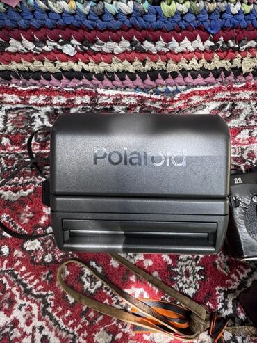 Фотоаппараты: Представлены две камеры: моментальная камера Polaroid в черном корпусе