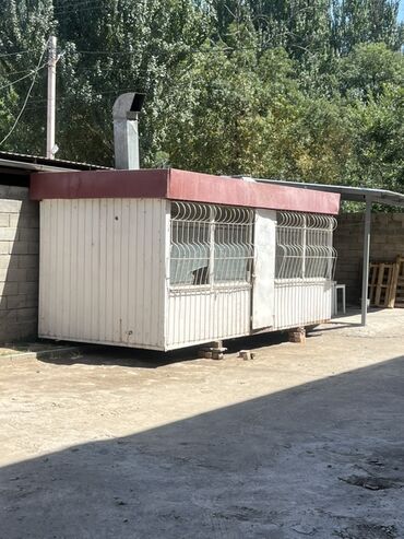 термо бутки: Киоск из белых панелей с красной крышей и металлическими решетками на