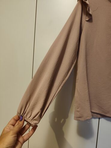 Bluze: Dve ženske bluze u nežnim neutralnim tonovima. 1) Puder‑roze bluza: - — 2