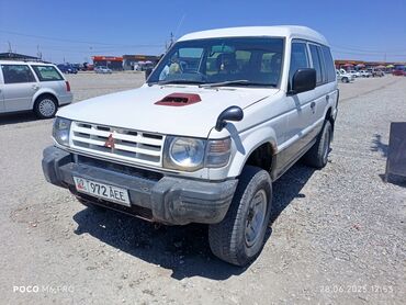 шины паджеро: Белый внедорожник Mitsubishi Pajero с запасным колесом, расположенным