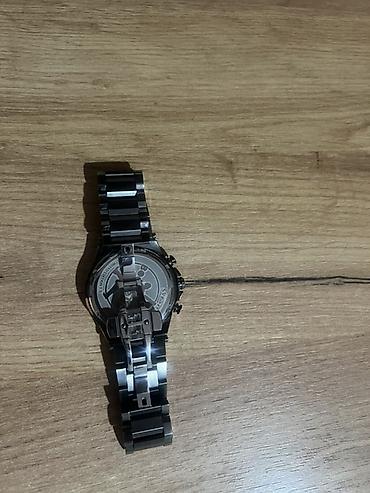 g shock kişi saatları: Qara rəngli, metal kəmərli kişi qol saatı. Saatın siferblatı — 2