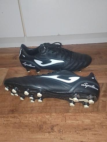 Kopačke: Kopačke Joma Aguila – crno‑bele - Model: Joma Aguila (logo i natpis — 2