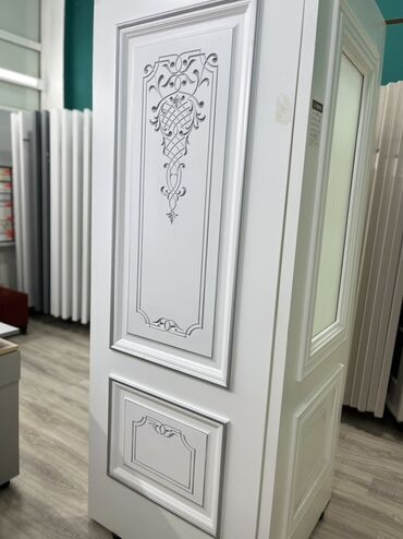Otaq qapıları: Ağ rəngdə, oyma naxışlı qapı. Qapının üzərində dekorativ çərçivələr və