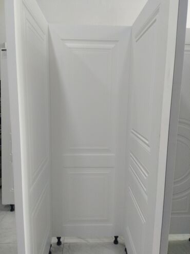 ağ qapılar: Ağ rəngdə, müasir dizaynlı qapı panelləri. Hər panelin üzərində iki