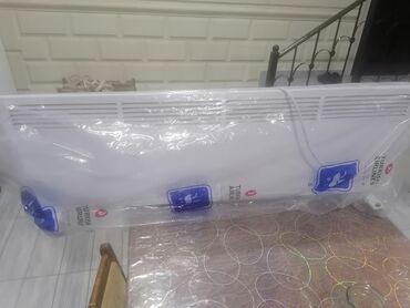 Ütülər və buxarlayıcılar: Ağ rəngdə, divara montaj oluna bilən elektrik qızdırıcı. Cihaz