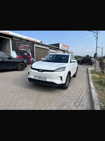 эмблема авто: Белый автомобиль BYD EV с современным дизайном кузова. Спереди