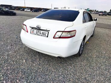 машины 2010 года и выше: Белый седан Toyota Camry — это автомобиль, предназначенный для