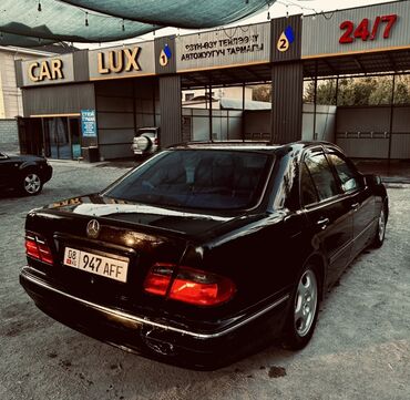 продаю мерс сешка: Черный седан Mercedes-Benz E-класса (W210) на автомойке. Автомобиль