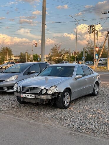 Mercedes-Benz: Автомобиль Mercedes-Benz E-класса серебристого цвета. Этот седан