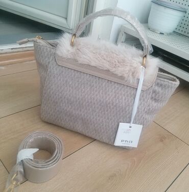 Torbe: Ženska torba sa preklopom od veštačkog krzna u bež boji. Torba ima dve — 7