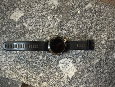 Garmin: Мужские смарт-часы Garmin с черным ремешком. Корпус часов выполнен в