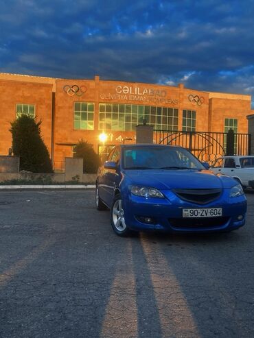 variator sürətlər qutusu: Mavi rəngdə "Mazda 3" sedan avtomobili. Avtomobilin qabaq hissəsi tünd